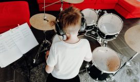 young-boy-learning-playing-drums-at-home-children - PJD7JRG